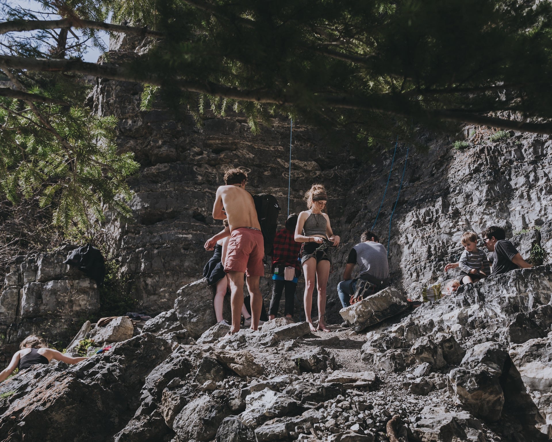 A group of friends praticing rock climbing on the mountains.